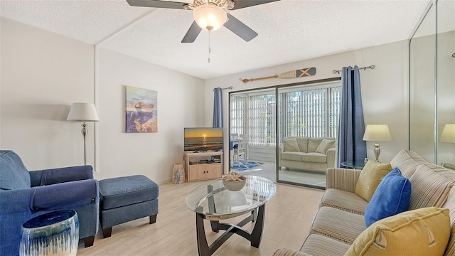 living room with ceiling fan, light hardwood / wood-style floors, and a textured ceiling