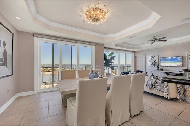 dining area with light tile patterned floors, ceiling fan with notable chandelier, a raised ceiling, and ornamental molding