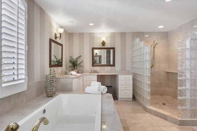 bathroom featuring tile patterned flooring, vanity, shower with separate bathtub, and a textured ceiling