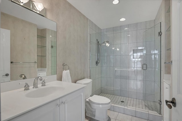 bathroom featuring toilet, vanity, tile patterned floors, and a shower with shower door