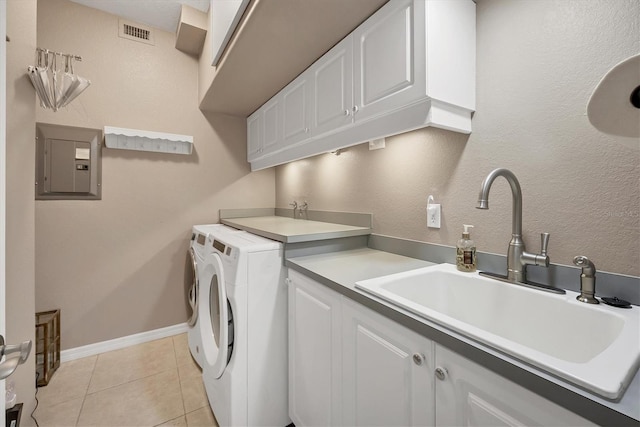 washroom with sink, cabinets, electric panel, light tile patterned flooring, and washer and dryer