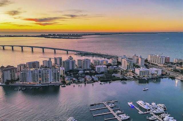 aerial view at dusk featuring a water view