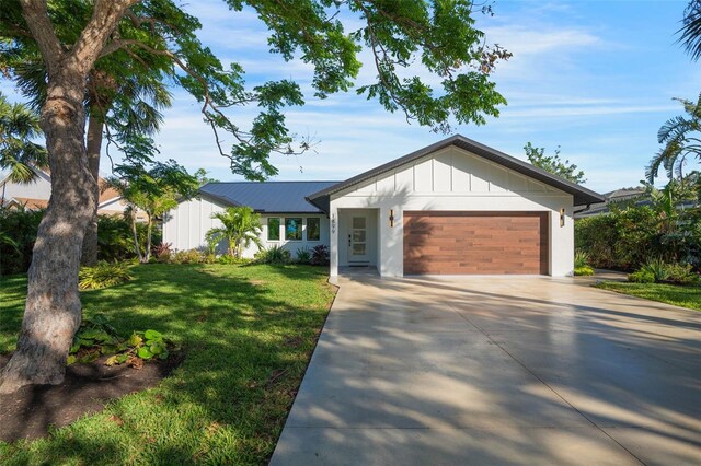 1899 Buccaneer Cir, Sarasota, FL 34231 - view of front facade with driveway, an attached garage, a front yard, and board and batten siding