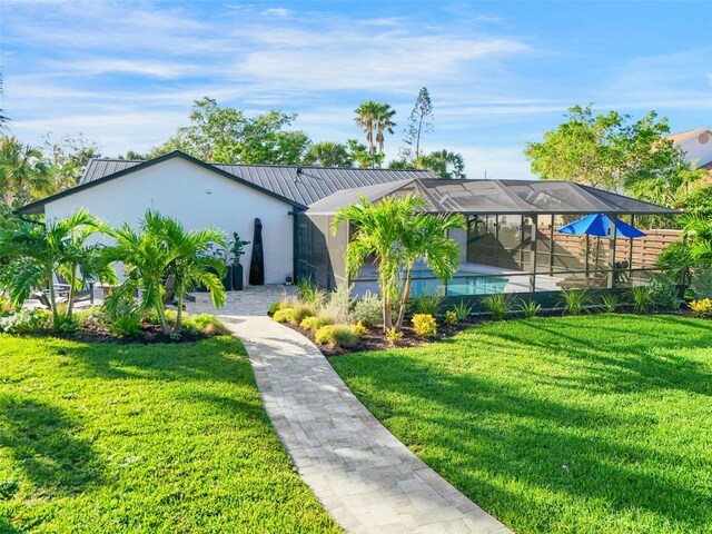 1899 Buccaneer Cir, Sarasota, FL 34231 - view of front facade with a front lawn, stucco siding, glass enclosure, and a metal roof