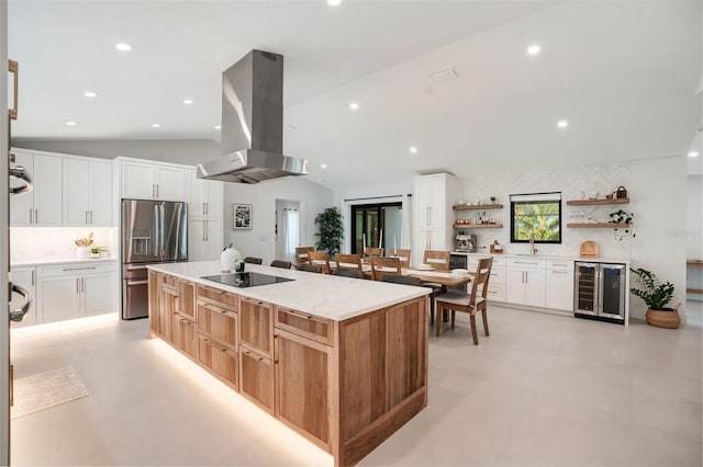 kitchen with wall chimney range hood, white cabinets, stainless steel fridge with ice dispenser, wine cooler, and lofted ceiling