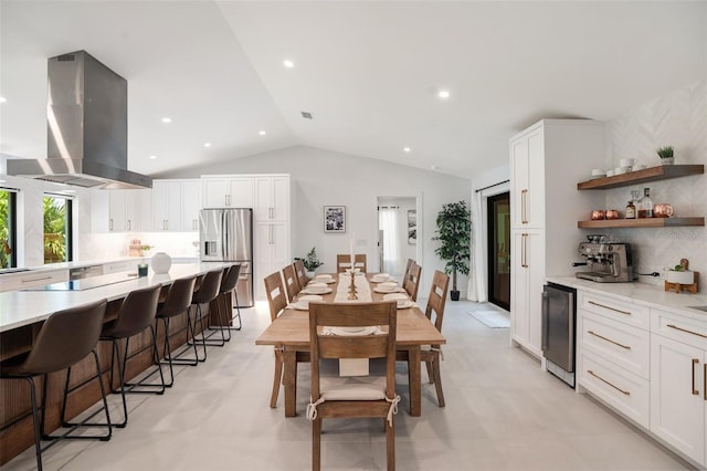 dining space featuring wine cooler and lofted ceiling