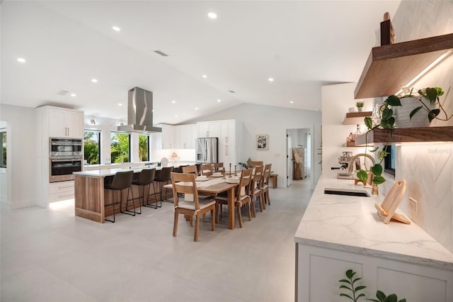 dining area with vaulted ceiling and sink