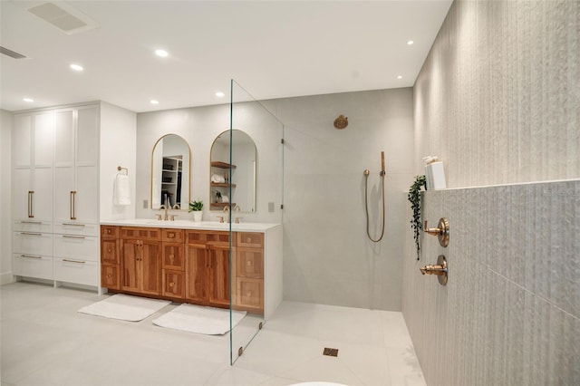 bathroom with a tile shower, tile patterned floors, and vanity