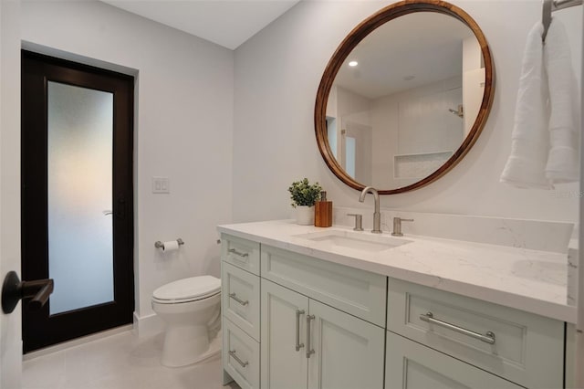 bathroom with tile patterned flooring, vanity, and toilet