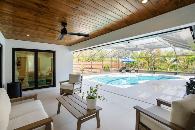 view of pool featuring outdoor lounge area, a patio, ceiling fan, and a lanai