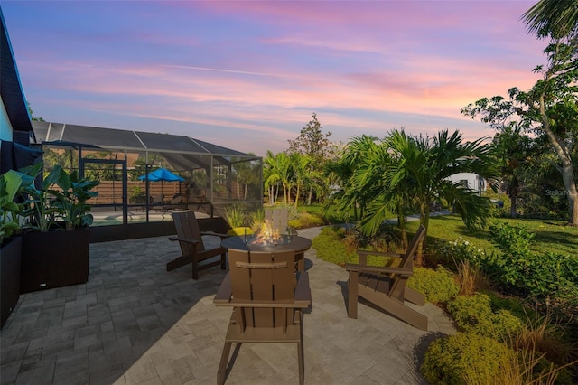 patio terrace at dusk with a lanai and an outdoor fire pit