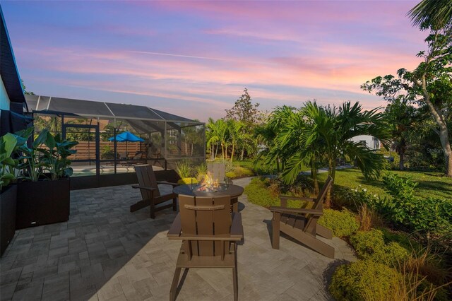 1899 Buccaneer Cir, Sarasota, FL 34231 - patio terrace at dusk with a fire pit, a patio, a lanai, and an outdoor pool