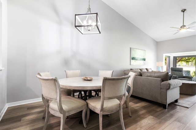 dining room featuring high vaulted ceiling, ceiling fan with notable chandelier, and dark hardwood / wood-style flooring