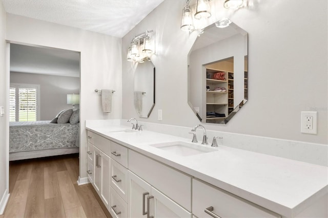 bathroom with hardwood / wood-style flooring, vanity, and a textured ceiling