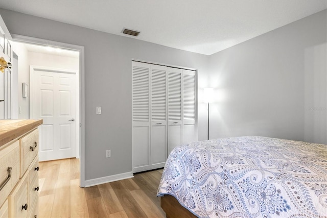 bedroom with light hardwood / wood-style flooring and a closet