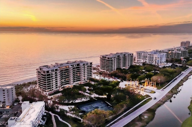 aerial view at dusk featuring a water view