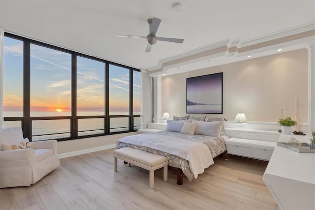 bedroom featuring ceiling fan, a water view, and light wood-type flooring