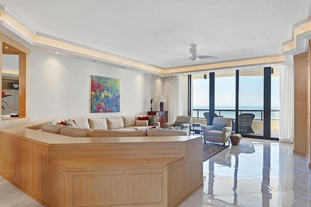 living room with ceiling fan, expansive windows, and a water view