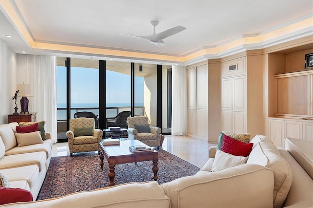 tiled living room with ceiling fan, floor to ceiling windows, a water view, and crown molding