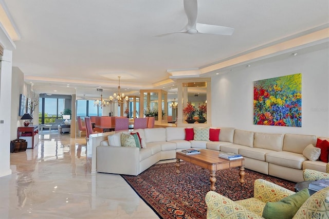 living room with ceiling fan with notable chandelier