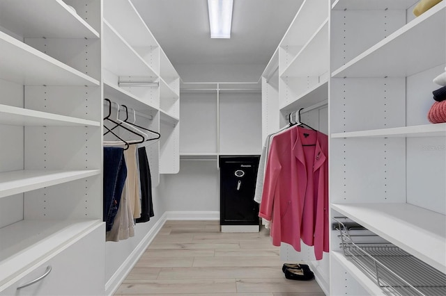 walk in closet with light wood-type flooring