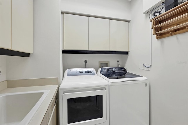 laundry room with cabinets, separate washer and dryer, and sink