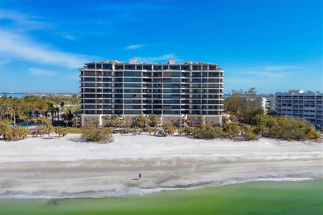 view of building exterior with a water view and a view of the beach