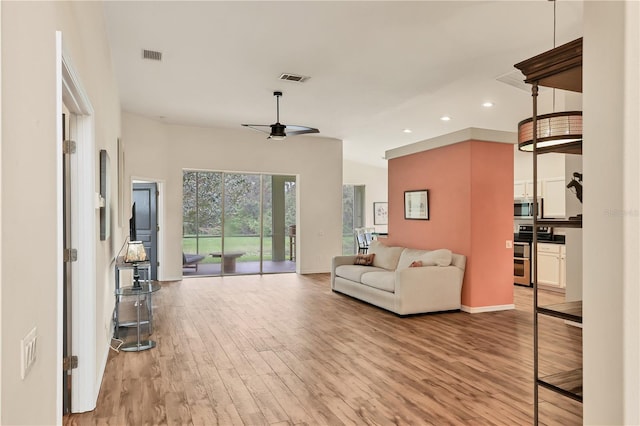 living room with light hardwood / wood-style floors and ceiling fan