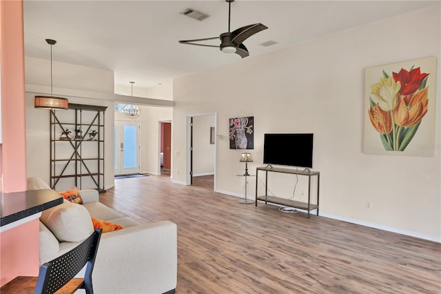 living room featuring hardwood / wood-style floors and ceiling fan with notable chandelier