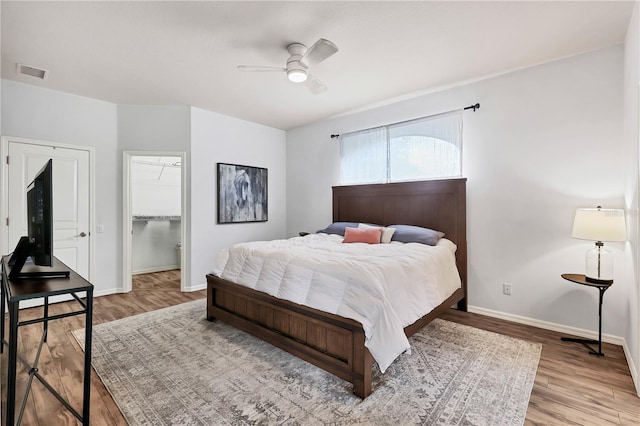 bedroom with a closet, ceiling fan, light hardwood / wood-style flooring, and a spacious closet