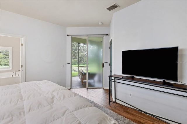 bedroom featuring access to outside, connected bathroom, and hardwood / wood-style flooring