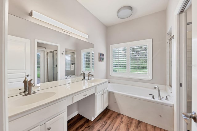 bathroom with hardwood / wood-style flooring, vanity, and shower with separate bathtub