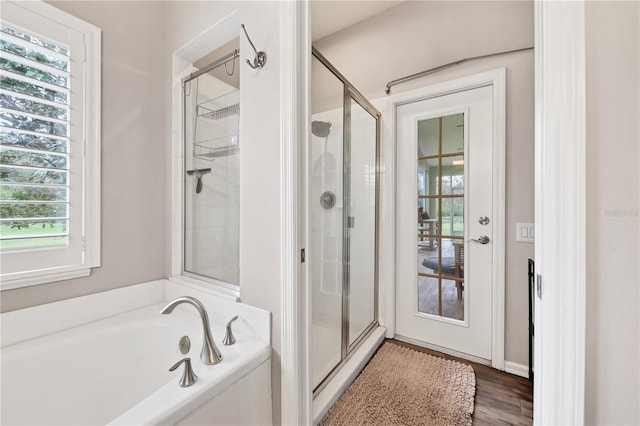 bathroom featuring wood-type flooring and plus walk in shower