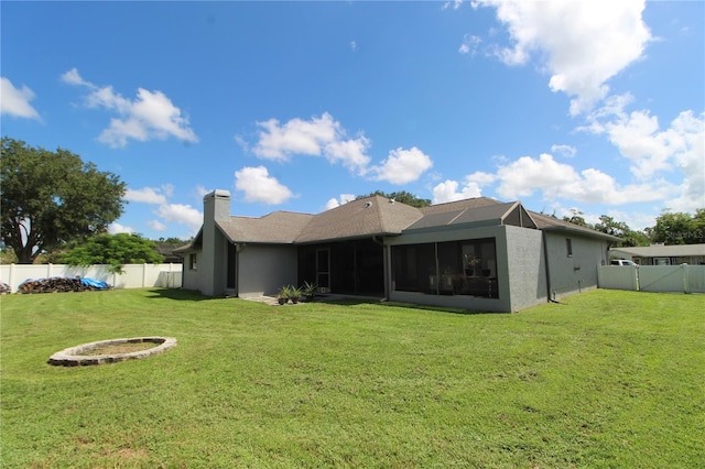 rear view of property featuring a yard and a sunroom