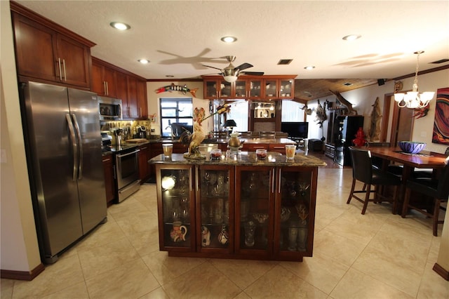 kitchen with a center island, ceiling fan with notable chandelier, hanging light fixtures, ornamental molding, and appliances with stainless steel finishes