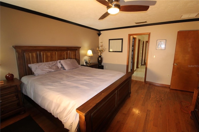 bedroom featuring ceiling fan, wood-type flooring, and ornamental molding