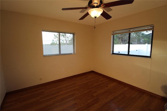 empty room featuring ceiling fan and dark hardwood / wood-style flooring