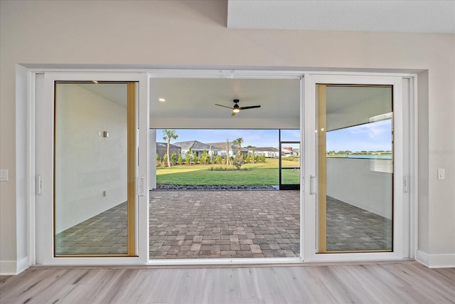 doorway featuring plenty of natural light, light hardwood / wood-style floors, and ceiling fan