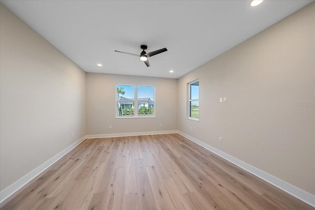 spare room with ceiling fan and light wood-type flooring