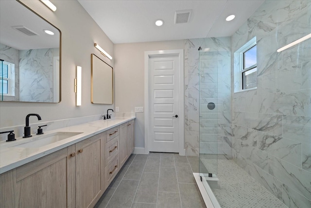 bathroom featuring tile patterned flooring, vanity, and tiled shower