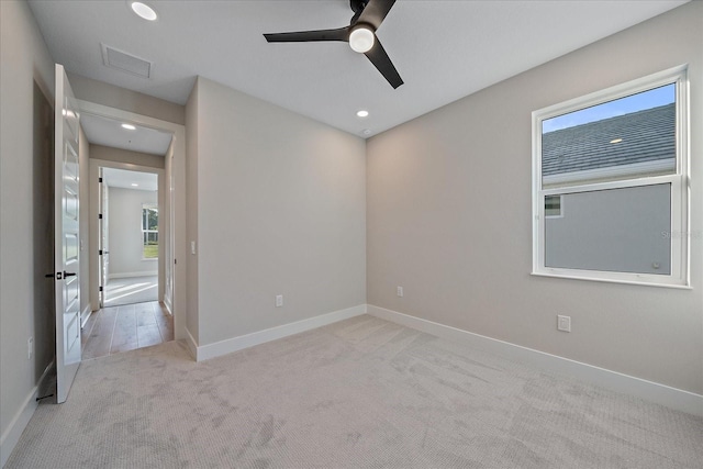 carpeted spare room with plenty of natural light and ceiling fan