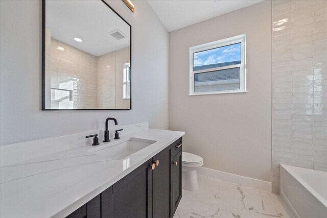 full bathroom with tiled shower / bath, vanity, and toilet