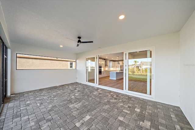 unfurnished sunroom featuring ceiling fan