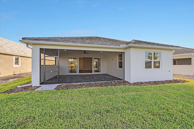 back of property featuring a sunroom and a lawn