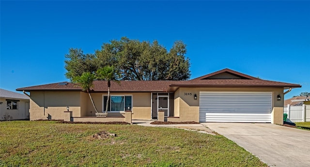 ranch-style home with a garage and a front lawn