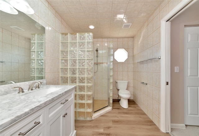 bathroom featuring walk in shower, wood-type flooring, and tile walls