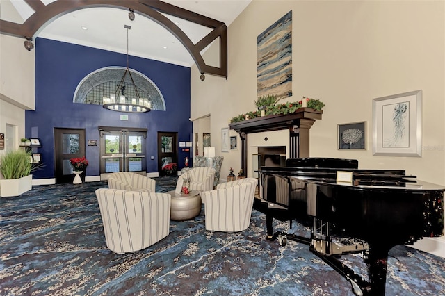 sitting room featuring a chandelier, french doors, and a towering ceiling