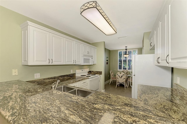 kitchen with white appliances, white cabinets, sink, dark stone countertops, and kitchen peninsula