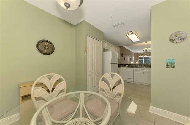 tiled dining space with sink and an inviting chandelier