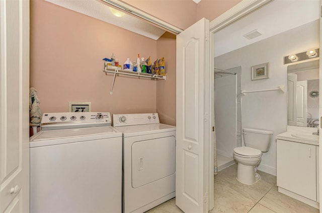 washroom with separate washer and dryer and sink